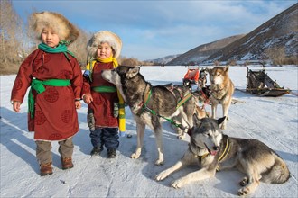 Children with huskies in front of dog sled
