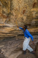 Guide pointing at cave paintings in Laas Geel caves