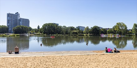 Sandy beach beach with bathers at the Woehrder See