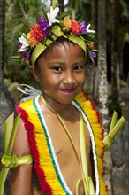 Child in traditional festive decoration with wreath of flowers