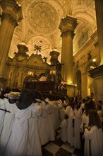 Penitents carry the Christ to the interior of the Cathedral of Jaen during the two encounter procession