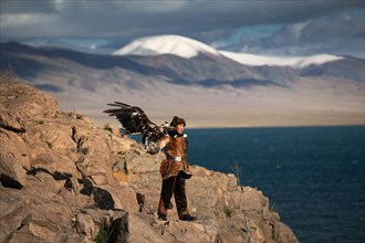 A young eagle huntress Zamanbol with her newly captured eagle. She is one of the few female hunters of Mongolia. Bayan-Ulgii province