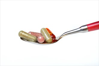 Capsules with food supplement in spoon