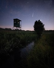 Perseids shooting star over field with hunter's seat