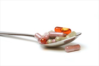 Capsules with food supplements in spoon