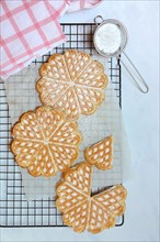 Waffles on cake rack and sieve with icing sugar