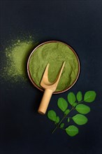 Moringa powder in bowl and Moringa leaves