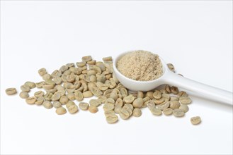 Green coffee beans and unroasted coffee powder in spoon