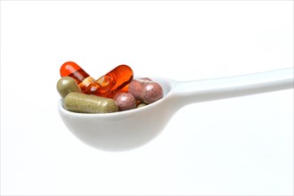 Capsules with food supplements in porcelain spoon
