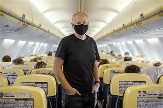 Man in protective mask standing in airplane