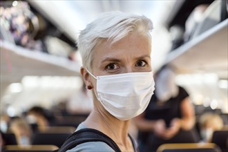 Woman standing in the airplane wearing face mask