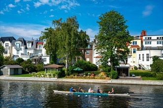 Rowing boat with recreational athletes on the Alster in Hamburg Winterhude