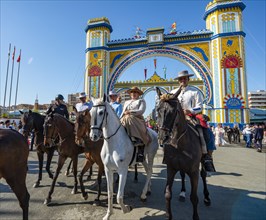 Riders on decorated horses in traditional dress in front of the entrance gate