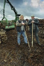 Men with a fork loading peat
