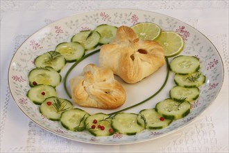 Puff pastry pocket enriched with cucumbers and slices of lime on plates