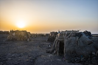 Village with huts of the Afar nomads at sunset