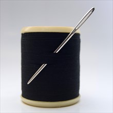 Close up of a needle and black thread