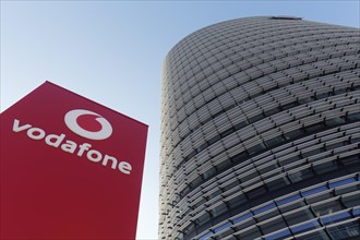 Pillar with Vodafone logo in front of the Vodafone high-rise building