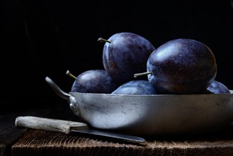 Plums in shell with knife