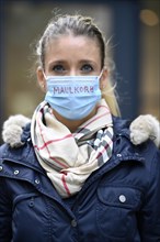 Woman with inscription MAULKORB on face mask