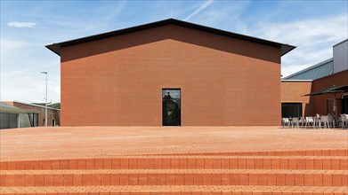Windowless red brick building in the shape of a warehouse