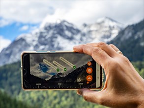 Hiker checks mountain peaks with the Peak Lens smartphone app