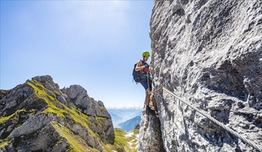 Young man climbing a rock face
