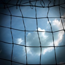 Football goal net against cloudy sky