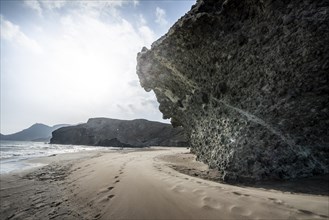 Petrified lava tongues and rocky coast at the beach Playa del Monsul