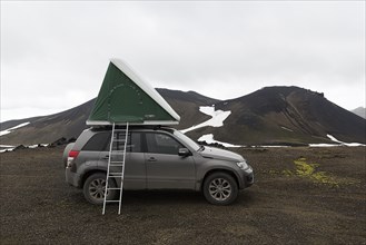 Off-road vehicle with roof tent and ladder