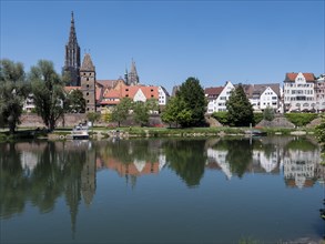 Ulm Cathedral and buildings on the banks of the Danube with water reflection