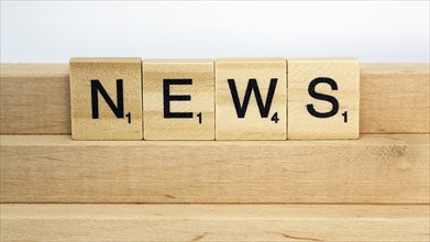 Letter blocks on a wooden bar form the word News