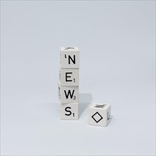 Cubes of letters stacked on top of each other form the word News