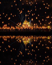 Yi Peng Festival with rising lanterns and a reflection in the lake