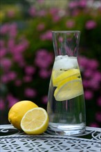 Lemon water in carafe and lemons