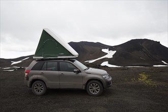 Off-road vehicle with roof tent in the mountains