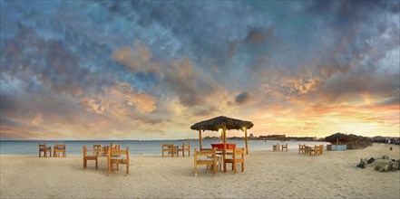 Sandy beach beach with bar at the coral reef Abu-Dabbab at sunset