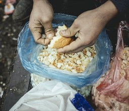 Refugee plucks bread for a meal in a shelter for refugees