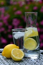 Lemon water in carafe and lemons
