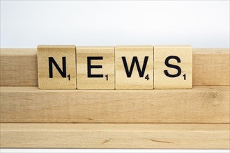 Letter blocks on a wooden bar form the word News