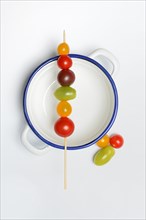 Various cherry tomatoes on wooden skewers on a bowl