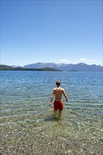 Young man bathes in the lake
