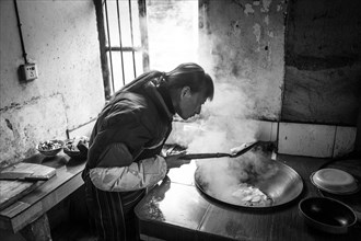Woman cooking in a farmhouse in Ping'An in Zhangjiajie National Forest Park