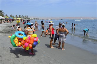 Beach saleswoman with colorful swimming tires and sand toys