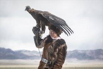 Young eagle hunter with her female eagle