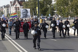 Police marches in front of demonstration march with portrait of Mahatma Gandhi
