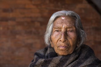 Portrait of an old Hindu woman wrapped in a blanket