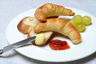 Croissants and slice of butter plait on plate