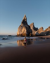 Marked rocks at Praia da Ursa beach with person