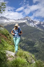 Hiker on hiking trail in front of mountains